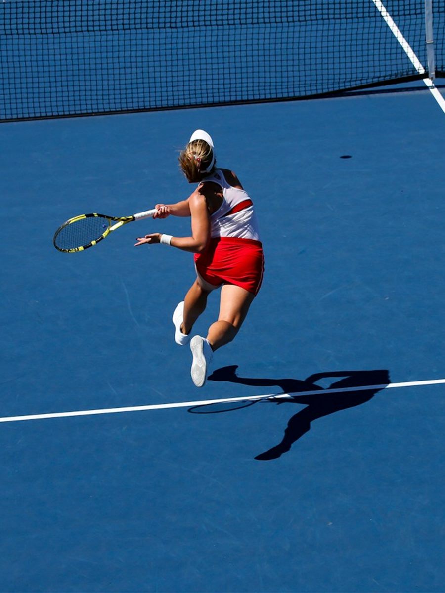 Tennisster slaat een smash op een hardcourt